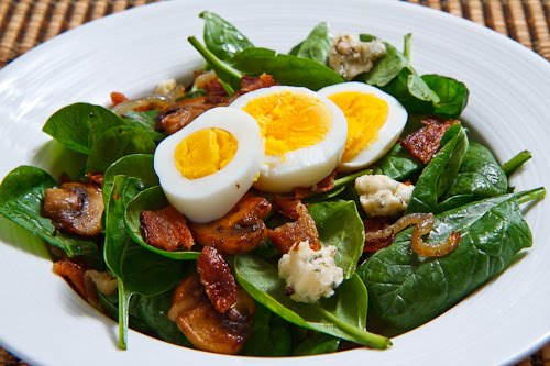 Spinach Salad with Bacon, Caramelized Onions, Mushrooms and Blue Cheese in a Bacon Pan Sauce Dressing Topped with a Hard Boiled Egg